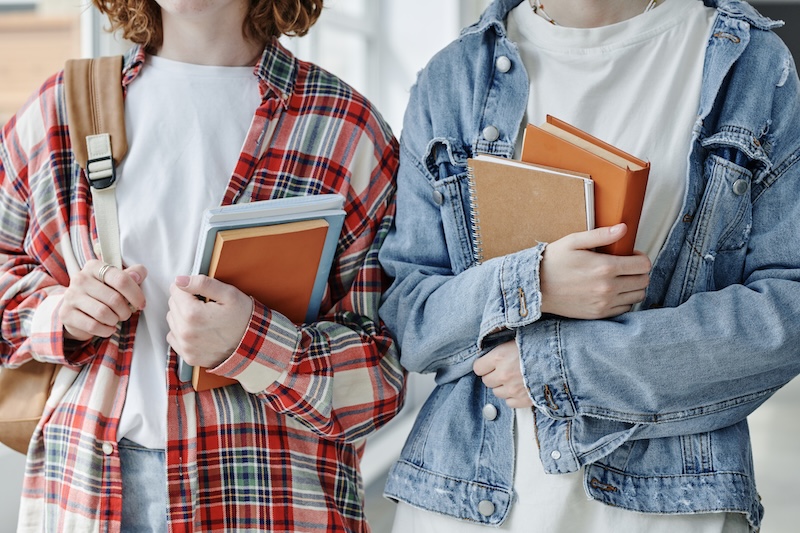 Zwei Jugendliche mit Schulbüchern als Symbolbild für Abitur und Oberstufe an der HEBO-Privatschule Mönchengladbach