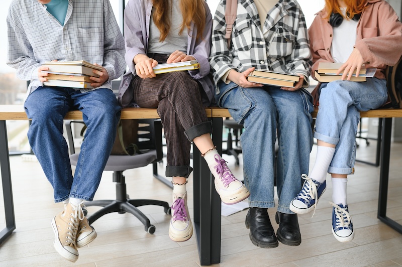 Gruppe von Jugendlichen mit Schulbüchern als Symbolbild für kleine Lerngruppen in der Oberstufe der HEBO-Privatschule Mönchengladbach